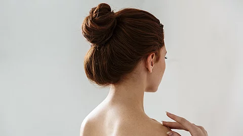 Beauty Portrait von einer jungen Frau mit hochgebundenen Haaren (Rückenansicht).