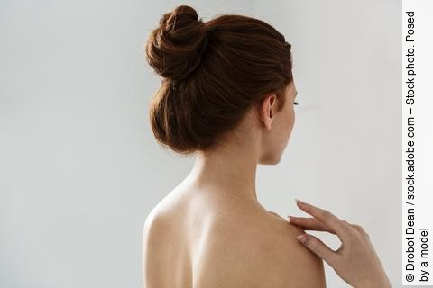 Beauty Portrait von einer jungen Frau mit hochgebundenen Haaren (Rückenansicht).