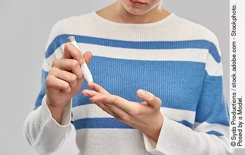 Frau misst ihren Blutzucker am Finger
