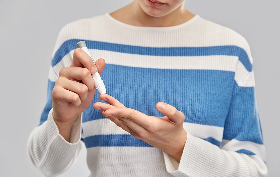 Frau misst ihren Blutzucker am Finger