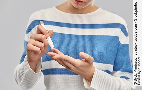 Frau misst ihren Blutzucker am Finger