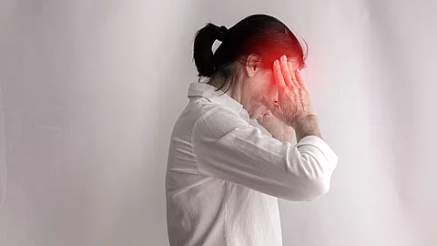 Frau mit Kopfschmerz hat die Hände an den Schläfen