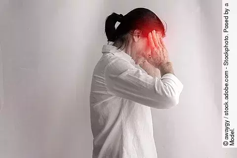 Frau mit Kopfschmerz hat die Hände an den Schläfen