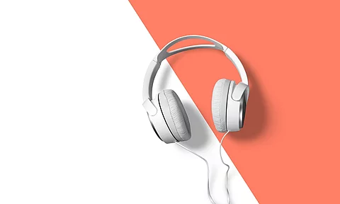 weiße Kopfhörer vor weiß-orangem Hintergrund