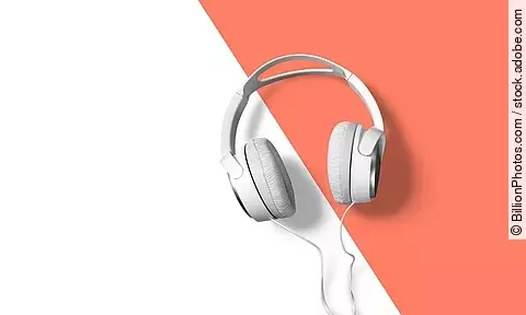 weiße Kopfhörer vor weiß-orangem Hintergrund