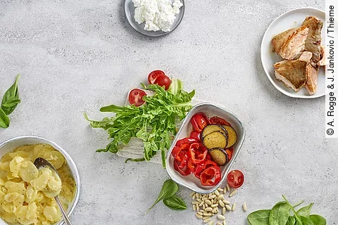 Tableau mit kleinen Gefäßen mit Lachs, Paprika, Kartoffelsalat und Dip