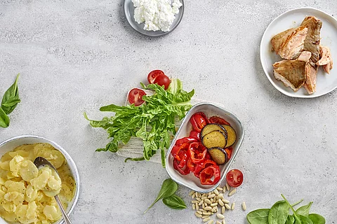 Tableau mit kleinen Gefäßen mit Lachs, Paprika, Kartoffelsalat und Dip