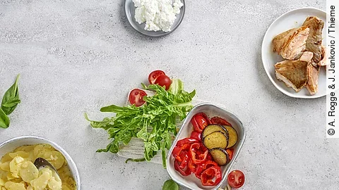 Tableau mit kleinen Gefäßen mit Lachs, Paprika, Kartoffelsalat und Dip