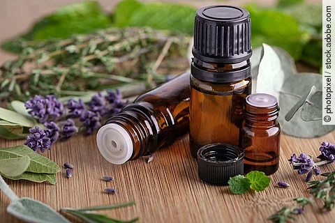 Aromatherapie: Lavendelzweige und Braunfläschchen auf einem Holztisch