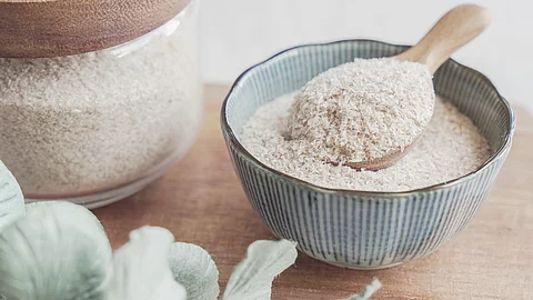 Flohsamenschalen in einer Schale mit Holzlöffel