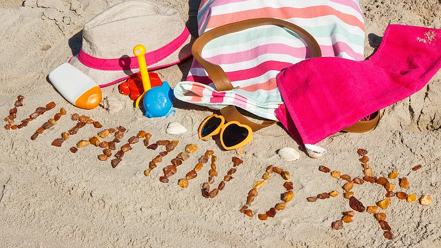 Inschrift Vitamin D mit Strandutensilien und Sonnensymbol Inschrift Vitamin D mit Strandutensilien und Sonnensymbol
