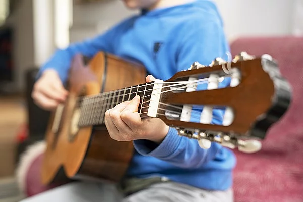 Ein Kind spielt Gitarre.
