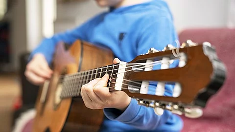 Ein Kind spielt Gitarre.