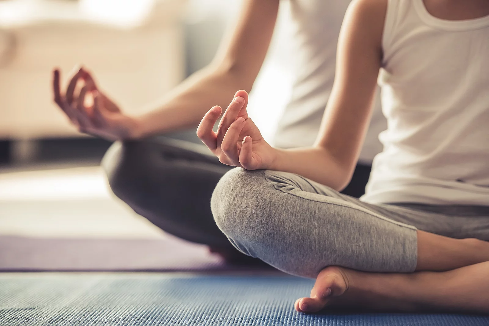 Zwei Frauen machen Yoga zu Hause.