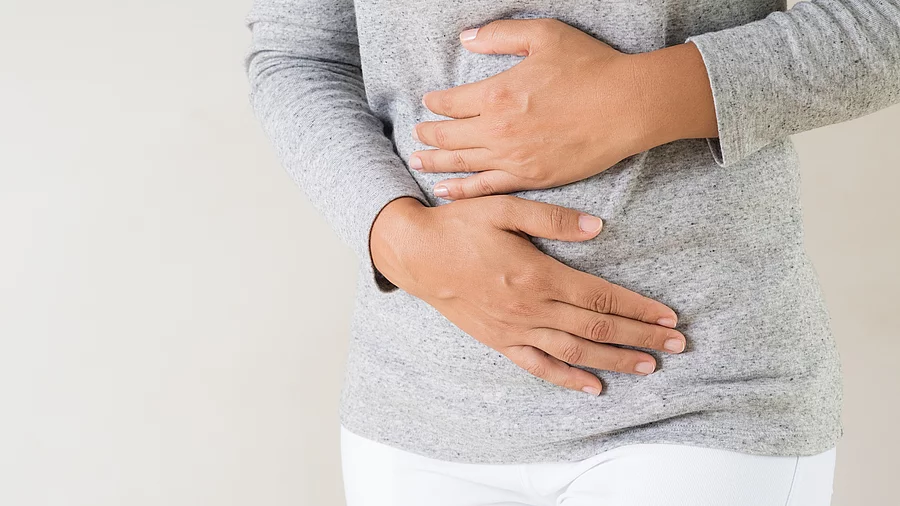 Frau hält sich mit beiden Händen den Bauch
