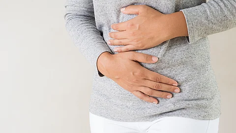 Frau hält sich mit beiden Händen den Bauch