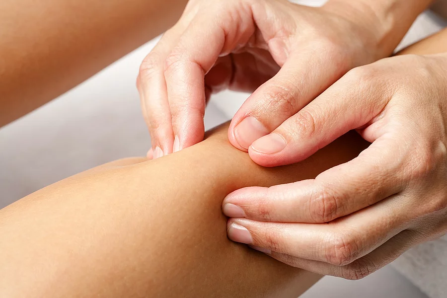 Nahaufnahme: Therapeut massiert den Arm einer Patientin.