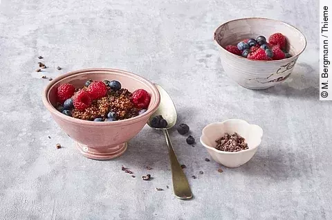 Beeren mit Qinoa-Porridge in Müslischalen angerichtet