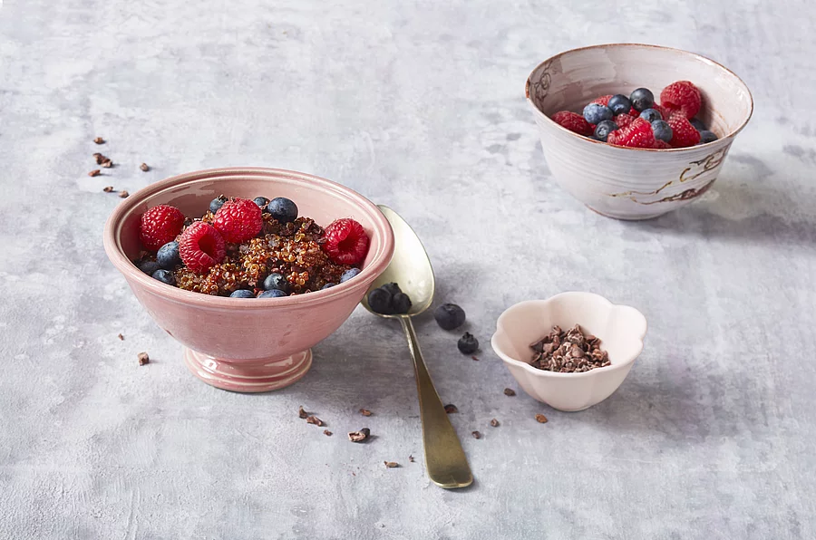 Beeren mit Qinoa-Porridge in Müslischalen angerichtet