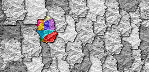 Bunter Papierausschnitt eines Kopfes inmitten von grauen Ausschnitten. 