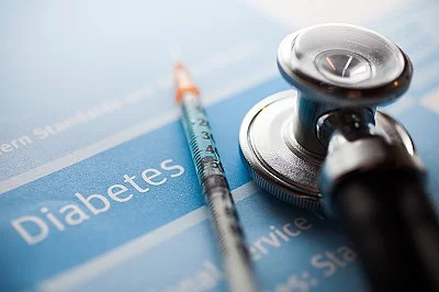 Ein Diabetestest auf dem ein Stethoskop und eine Spritze liegen. 