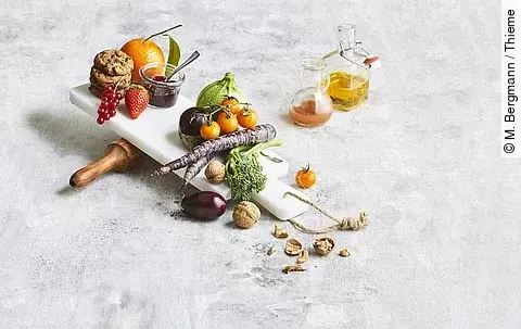 Obst, Gemüse, Marmelade, Nüsse, Cookies, Öl und Saft ästhetisch gruppiert auf weißem Untergrund