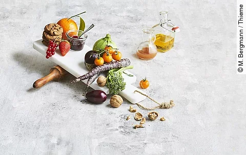 Obst, Gemüse, Marmelade, Nüsse, Cookies, Öl und Saft ästhetisch gruppiert auf weißem Untergrund