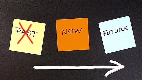 Bunte Klebezettel auf denen past, present und future steht.