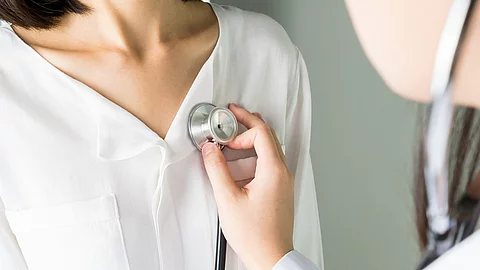 Ärztin untersucht Patient*in mit einem Stethoskop. 