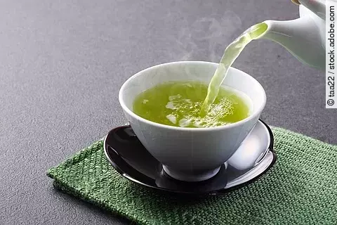 Teekanne und Teetasse mit grünem Tee