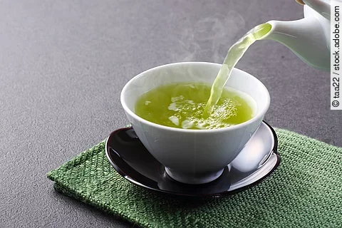 Teekanne und Teetasse mit grünem Tee