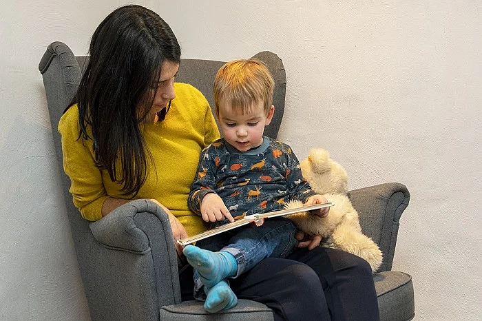 Mutter liest ihrem Kleinkind aus einem Buch vor