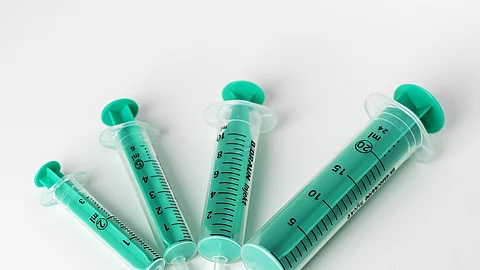 4 grüne Spritzen in verschiedene Größen im Halbkreis auf weißem Grund 