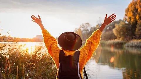 Frau mit Rucksack am See, Freude