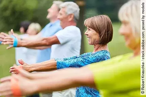 Gruppe von Senioren, die Übungen mit Fitnessbändern macht.