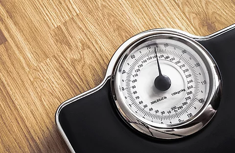 Schwarze Waage auf einem Holzboden.