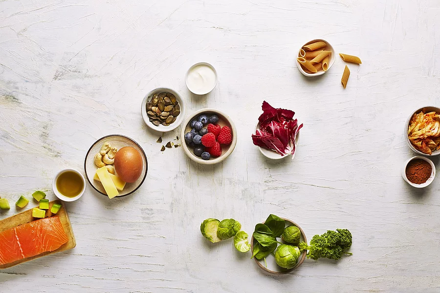 gesunde Lebensmittel: Beeren, Kürbiskerne, Vollkornnudeln, Lachs, Avocado, Salat, Rosenkohl