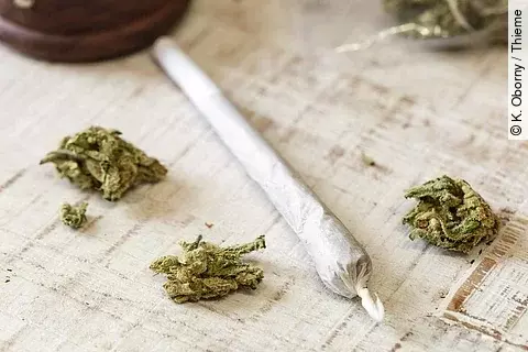 Cannabisblüten und gedrehter Joint auf einem Tischtuch