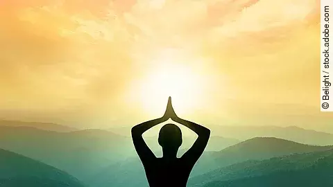 Yoga und Meditation: Frauensilhouette vor Bergen