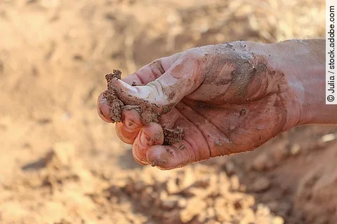 Lehmverschmierte Hände