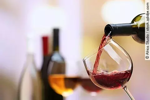 Rotwein wird aus einer Flasche ins Glas gegossen