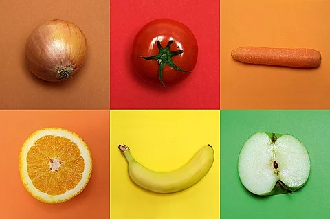 Zwiebel, Tomate, Möhre, Orange, Banane, Apfel auf farbigem Hintergrund