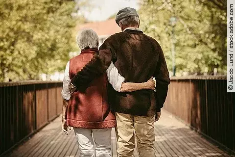 Senior couple walking through a park