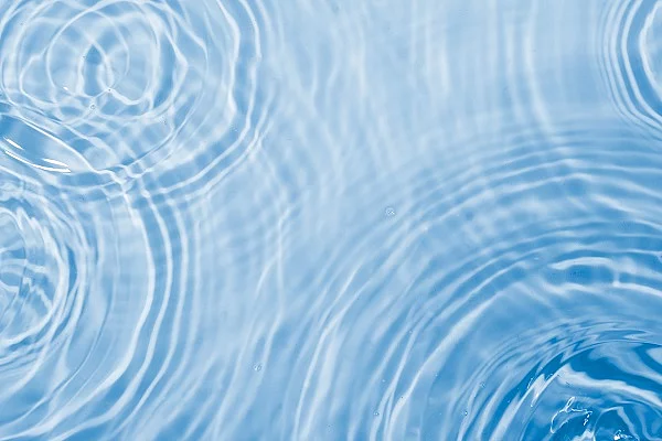 Wassertropfen und unruhige Wasseroberfläche