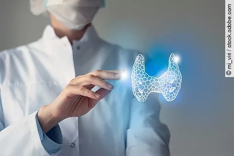Arzt streckt die Hand nach der 3D-Illustration einer menschlichen Schilddrüse aus.