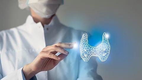 Arzt streckt die Hand nach der 3D-Illustration einer menschlichen Schilddrüse aus.