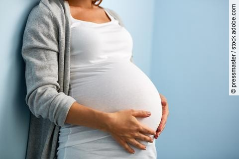Schwangere Frau hält ihren Bauch.