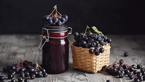 frische Aroniabeeren in Bastkorb, Aroniabeermus im Weckglas