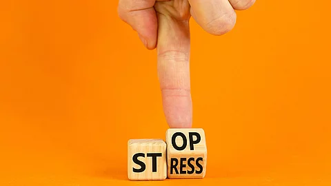 Stress stoppen. Würfel mit den Worten Stop und Stress vor orangefarbenem Hintergrund.