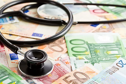 Stethoskop liegt auf Geldscheinen.